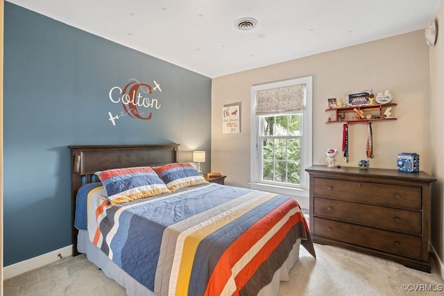 bedroom featuring light colored carpet and baseboards