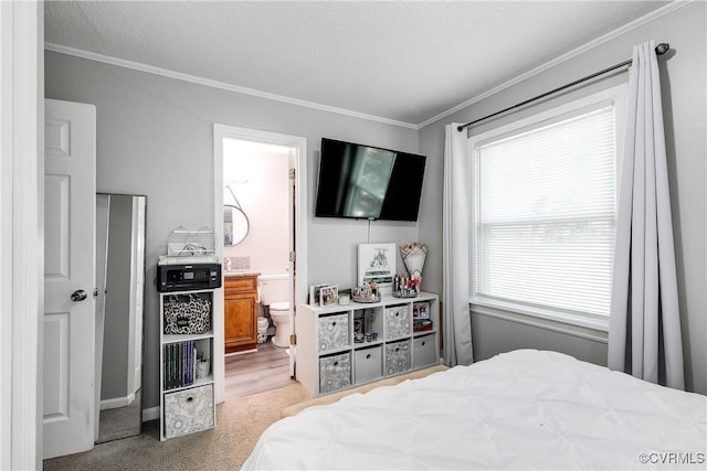 bedroom featuring ornamental molding, light carpet, and ensuite bath