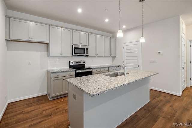 kitchen with a sink, appliances with stainless steel finishes, baseboards, dark wood-style flooring, and backsplash