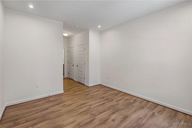 unfurnished bedroom featuring baseboards, wood finished floors, recessed lighting, and a closet