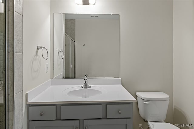 bathroom featuring vanity, toilet, and a shower stall