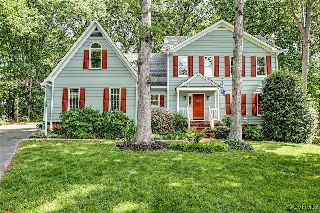 view of front of home featuring a front lawn and roof with shingles