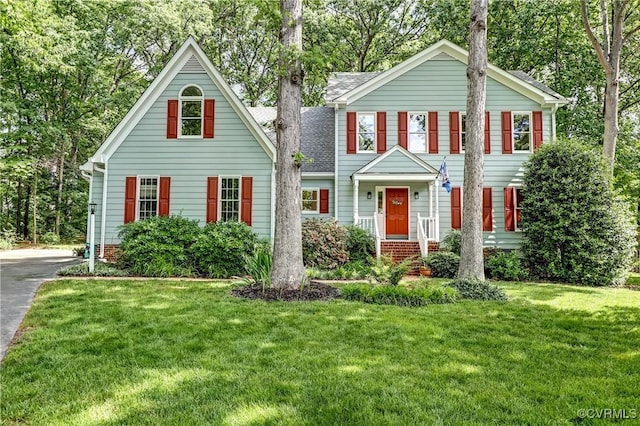 view of front of home featuring a front lawn and roof with shingles