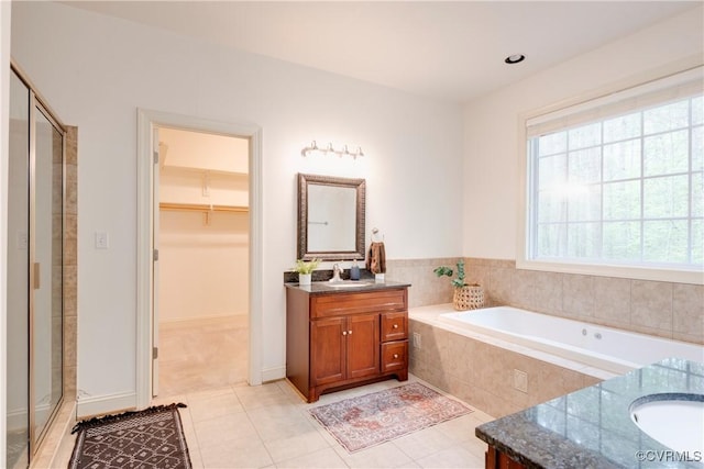 5470 Tyshire Pkwy, Providence Forge, VA 23140 - full bath featuring vanity, a shower stall, a spacious closet, a garden tub, and tile patterned flooring