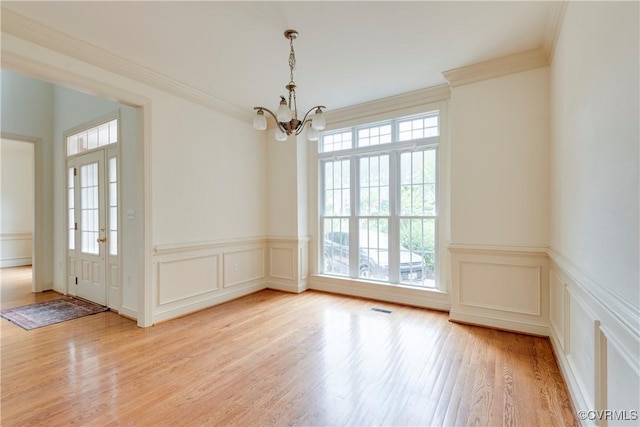5470 Tyshire Pkwy, Providence Forge, VA 23140 - unfurnished dining area featuring a chandelier, a decorative wall, light wood-style flooring, crown molding, and wainscoting