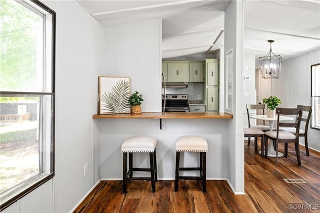 kitchen featuring butcher block counters, stainless steel range with electric stovetop, dark wood finished floors, a chandelier, and baseboards