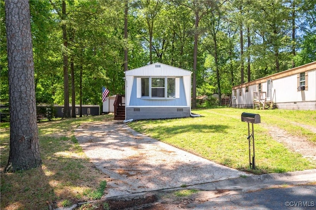 view of front of property with crawl space, driveway, and a front yard