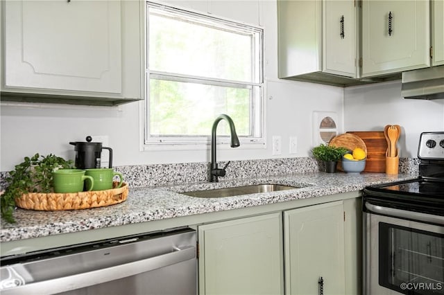 kitchen featuring appliances with stainless steel finishes, a sink, wall chimney exhaust hood, and light stone counters