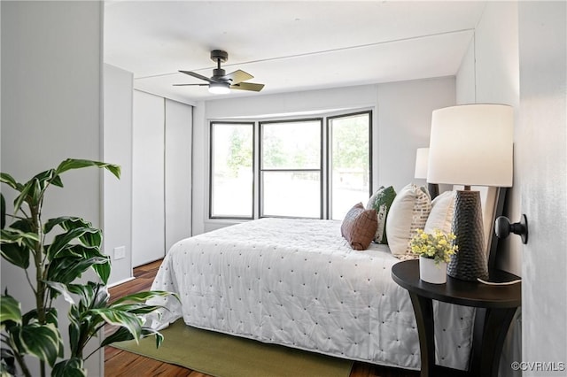 bedroom featuring wood finished floors, ceiling fan, and a closet