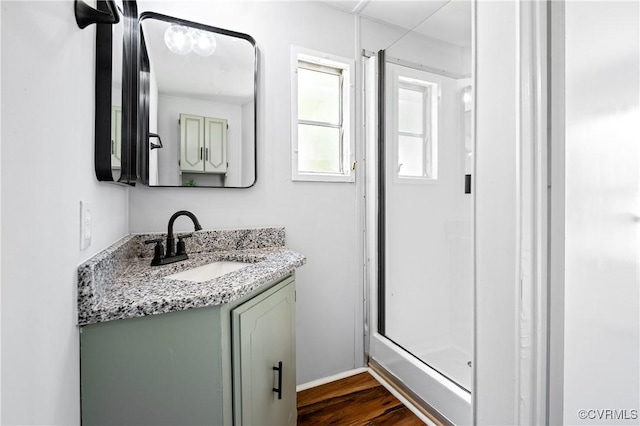 bathroom with vanity, wood finished floors, and a shower