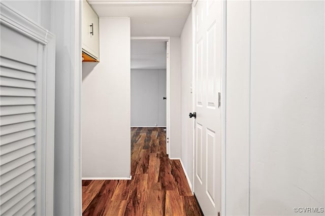hallway with dark wood-style flooring and baseboards