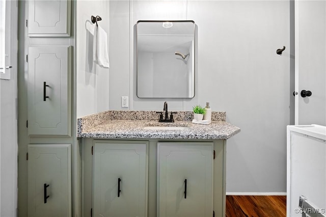 bathroom featuring wood finished floors, vanity, and baseboards
