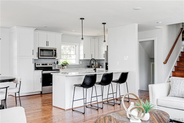 7910 San Juan Rd, Henrico, VA 23229 - kitchen with stainless steel appliances, a kitchen breakfast bar, a peninsula, decorative backsplash, and light countertops