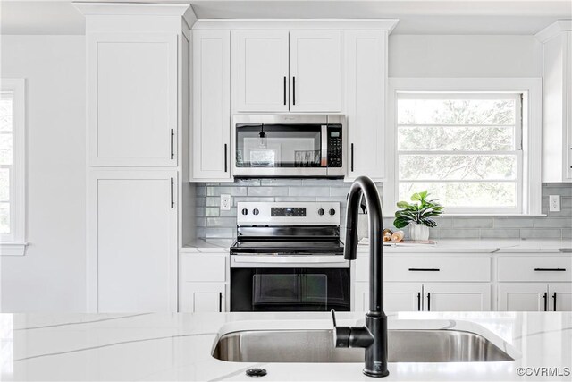 7910 San Juan Rd, Henrico, VA 23229 - kitchen with appliances with stainless steel finishes, tasteful backsplash, white cabinets, and a sink