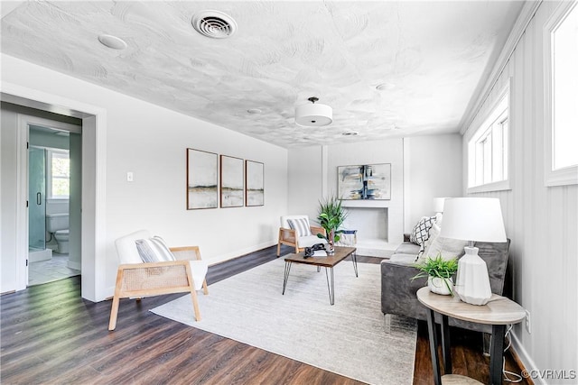 living area with dark wood-style flooring and baseboards