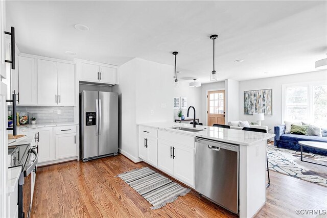7910 San Juan Rd, Henrico, VA 23229 - kitchen featuring stainless steel appliances, a sink, a peninsula, and light wood-style floors