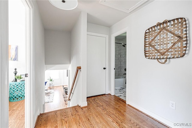 corridor featuring wood finished floors and baseboards