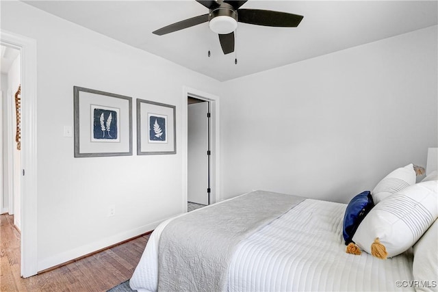 bedroom featuring wood finished floors, baseboards, and a ceiling fan