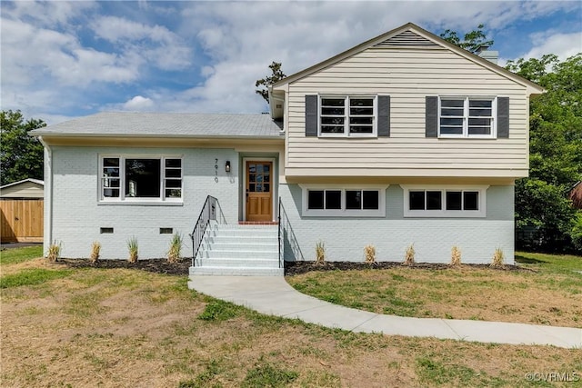 tri-level home featuring brick siding and crawl space