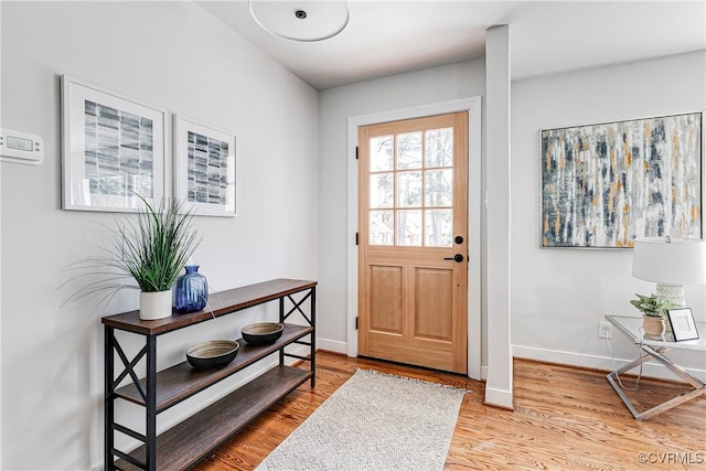 doorway to outside featuring wood finished floors and baseboards