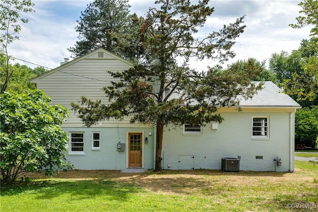 rear view of house featuring central AC unit, crawl space, a lawn, and brick siding