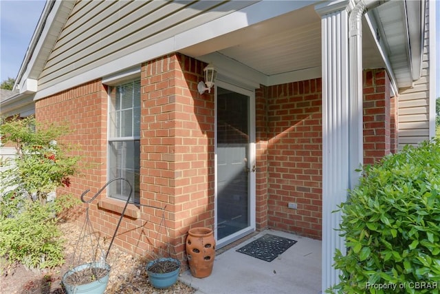 doorway to property with brick siding