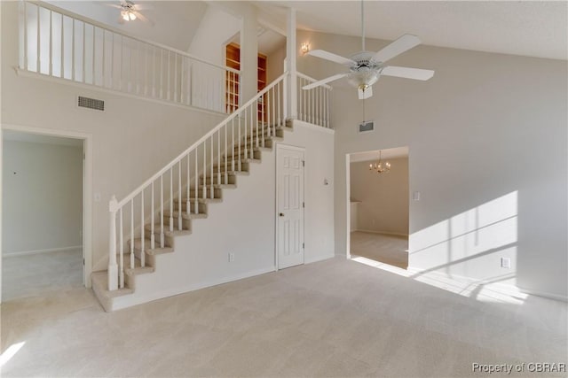 unfurnished living room with stairs, a ceiling fan, high vaulted ceiling, carpet, and baseboards