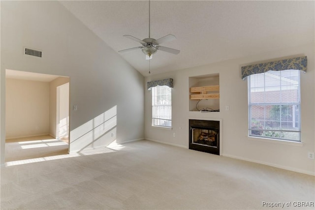 unfurnished living room featuring a ceiling fan, carpet floors, a fireplace, baseboards, and high vaulted ceiling