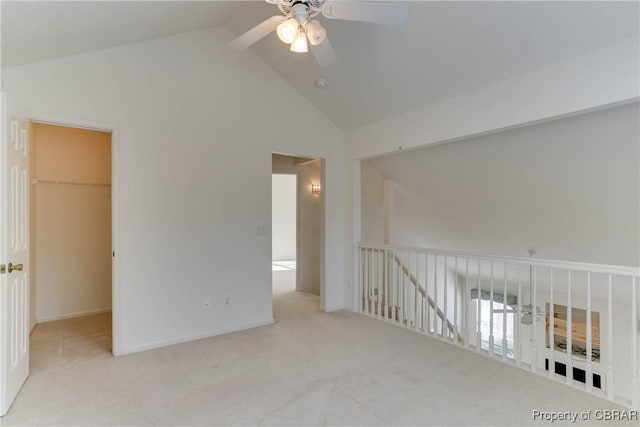 carpeted spare room with a ceiling fan, high vaulted ceiling, and baseboards