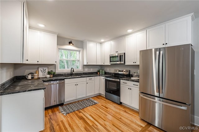 6101 Lewis Rd, North Dinwiddie, VA 23803 - kitchen with appliances with stainless steel finishes, white cabinetry, recessed lighting, light wood-style floors, and a sink