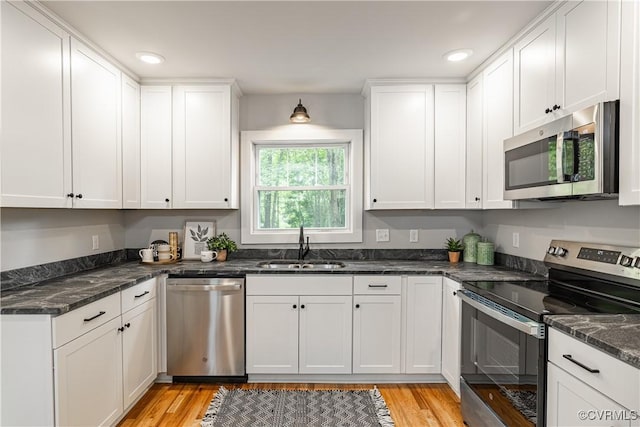 6101 Lewis Rd, North Dinwiddie, VA 23803 - kitchen featuring appliances with stainless steel finishes, a sink, white cabinets, light wood-type flooring, and recessed lighting