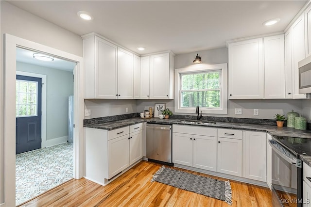 6101 Lewis Rd, North Dinwiddie, VA 23803 - kitchen with appliances with stainless steel finishes, a sink, white cabinets, light wood-type flooring, and plenty of natural light