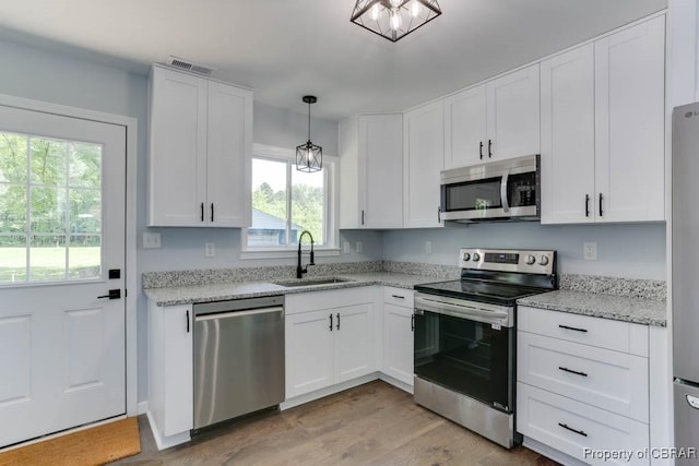 917 Chapel Neck Rd, North, VA 23128 - kitchen featuring stainless steel appliances, a sink, white cabinets, and light wood finished floors
