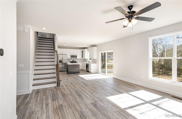 409 Confederate Dr, Orange, VA 22508 - unfurnished living room featuring light wood-type flooring, stairs, a ceiling fan, recessed lighting, and a sink