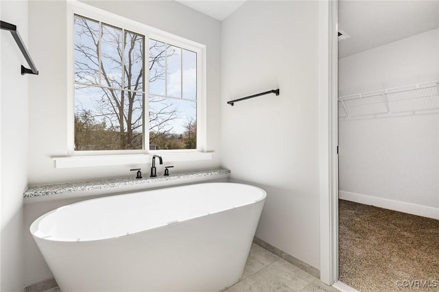 409 Confederate Dr, Orange, VA 22508 - bathroom with a walk in closet, a freestanding tub, and baseboards
