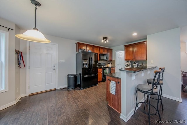 5631 Buckhunt Ln, New Kent, VA 23124 - kitchen featuring black appliances, a kitchen breakfast bar, brown cabinets, dark wood-type flooring, and a peninsula