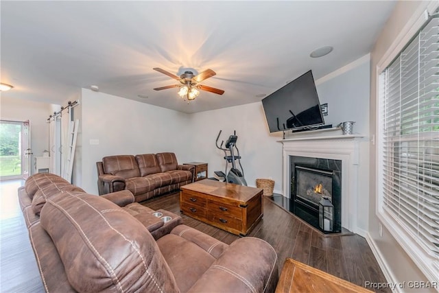 5631 Buckhunt Ln, New Kent, VA 23124 - living room featuring wood finished floors, a ceiling fan, a lit fireplace, and baseboards