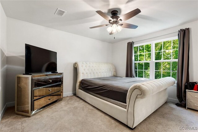 bedroom featuring light colored carpet, a ceiling fan, and baseboards