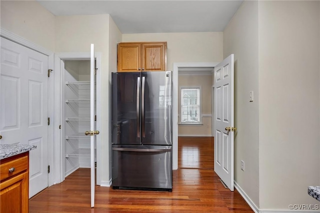 4221 Hunter Green Ct, Henrico, VA 23294 - kitchen with freestanding refrigerator, wood finished floors, light stone countertops, baseboards, and brown cabinets