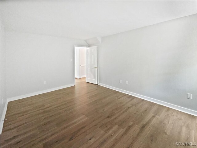 unfurnished room with dark wood-style flooring and baseboards
