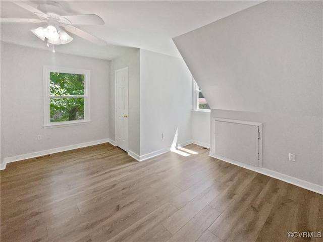 additional living space featuring wood finished floors, baseboards, and ceiling fan