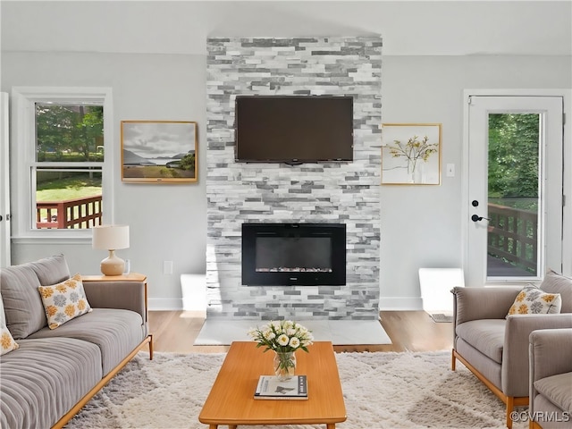 living area with plenty of natural light, wood finished floors, and baseboards
