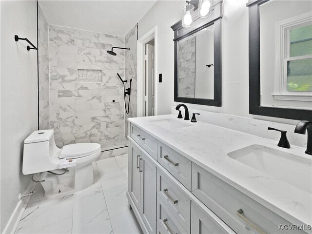 bathroom featuring marble finish floors, toilet, tiled shower, and double vanity