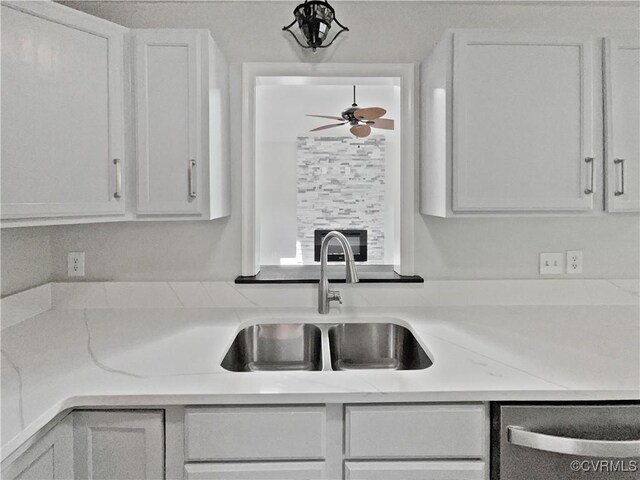 kitchen with a sink, white cabinets, and dishwasher