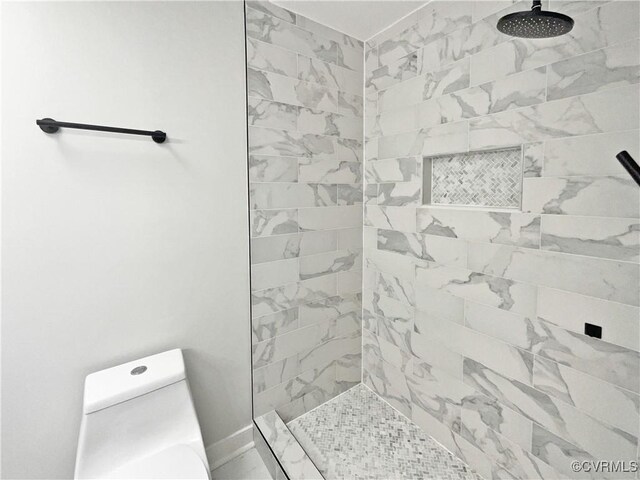 full bath with tiled shower and toilet