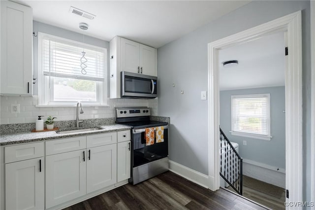 1811 Fenton St, Richmond, VA 23231 - kitchen with appliances with stainless steel finishes, a sink, dark wood-style flooring, white cabinets, and decorative backsplash