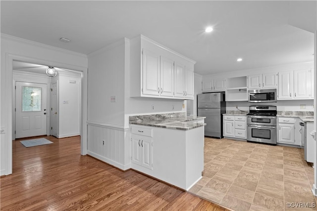 kitchen with stainless steel appliances, open shelves, white cabinets, light stone countertops, and crown molding