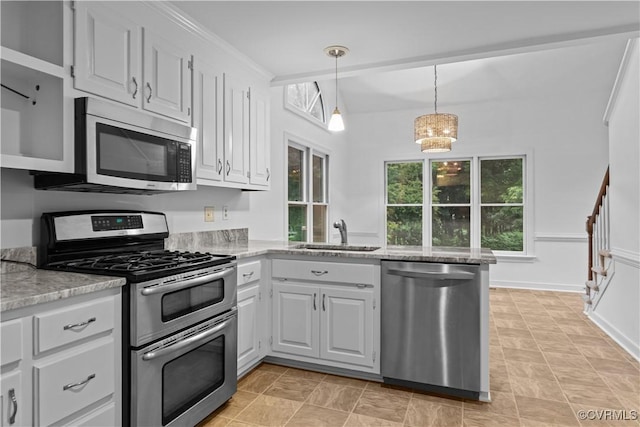 kitchen with stainless steel appliances, a sink, a peninsula, pendant lighting, and white cabinetry