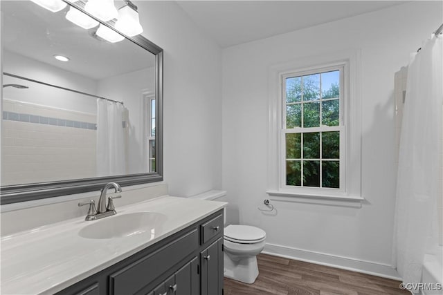 bathroom featuring wood finished floors, toilet, curtained shower, vanity, and baseboards