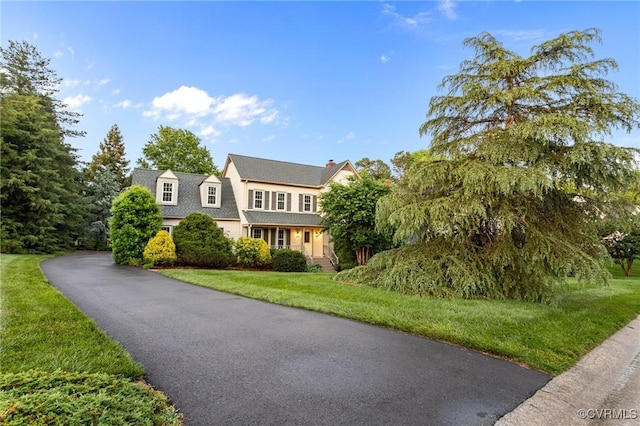 view of front of house featuring a front lawn and a chimney